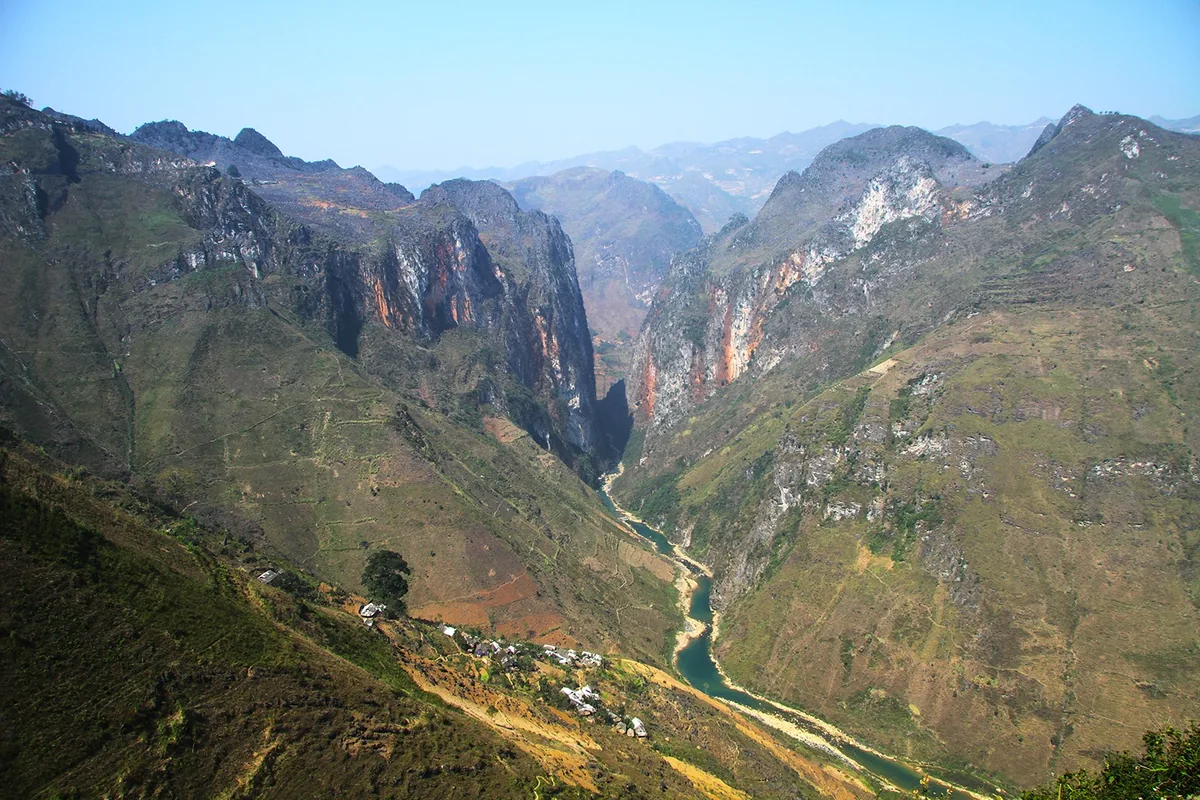 The Tu San Canyon in Ha Giang cuts a deep gorge with the Nho Que River winding below rugged limestone mountains.