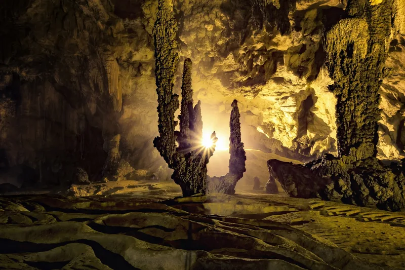 Sunlight streams through jagged stalagmites inside Nguom Ngao Cave in Cao Bang.